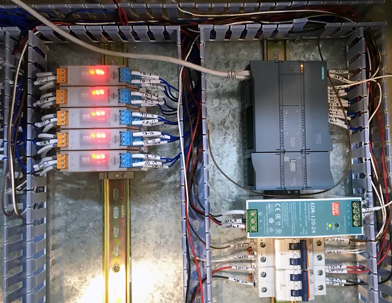 Powered-up panel with five isolators, a Siemens S7-1200 PLC with an SM 1231 analog input module, a 24 V DC supply and MCBs